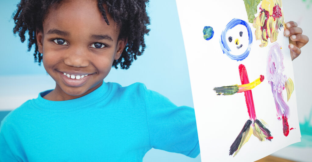 Image of a kid holding his artwork