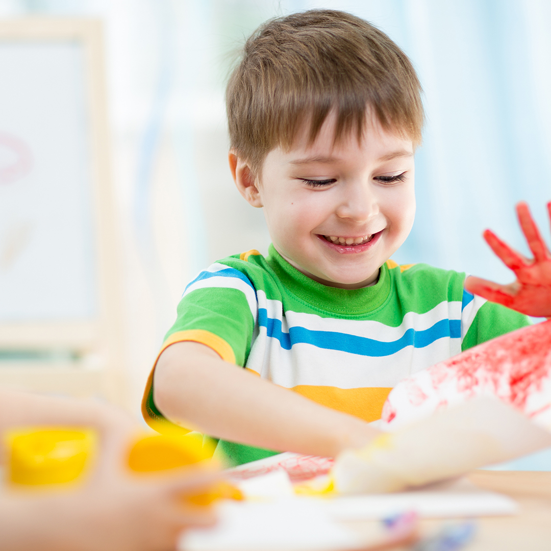 Image of a kid painting with his hands