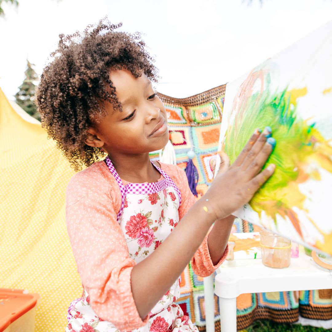 a kid using her palms to paint