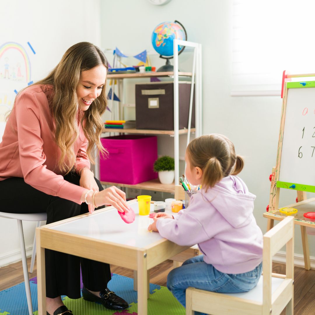 child sitting at desk with instructor