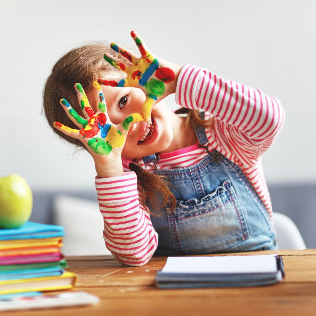 preschooler smiling with paint on her hands